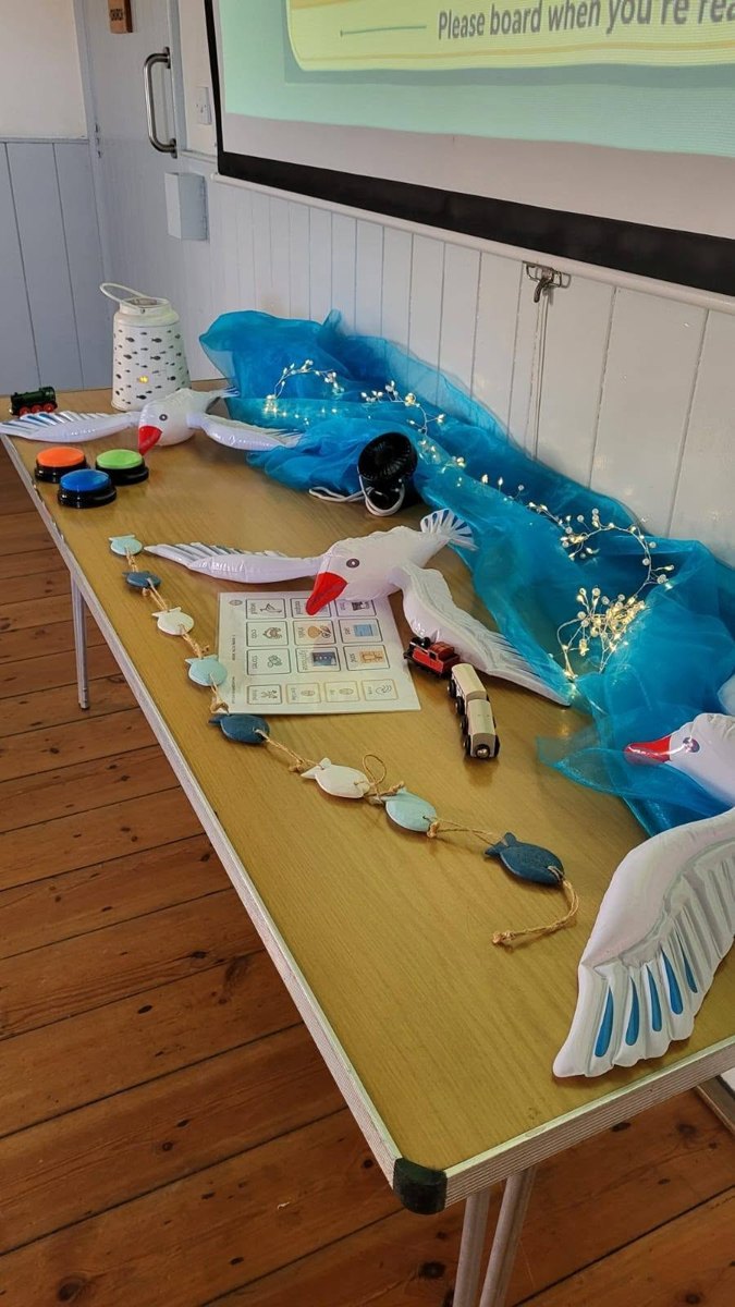 The seaside story table with blue fabric, seabirds, lights and visual prompts.